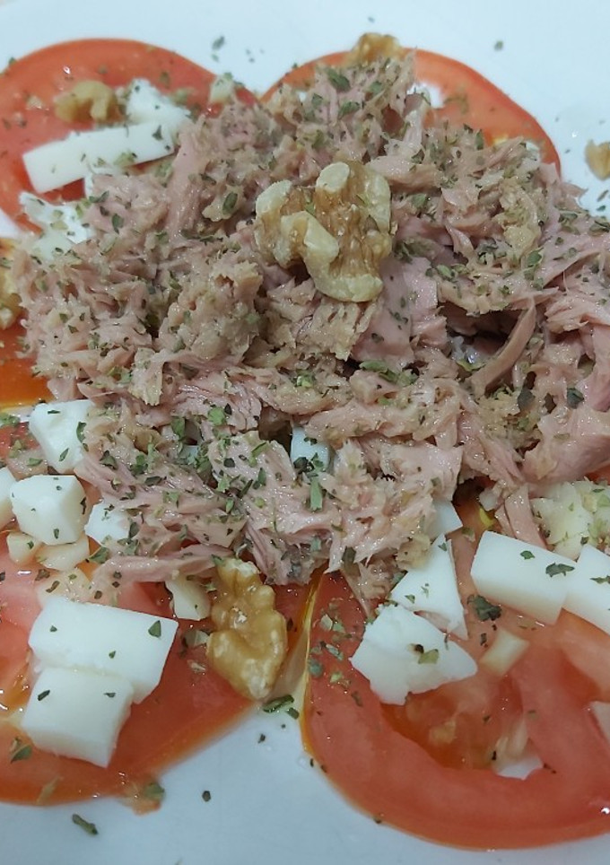 Una foto de Aliño de tomate con queso y atún.
