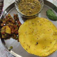 A picture of Makai roti with dal makhni aloo gajar methi matar sabzi.