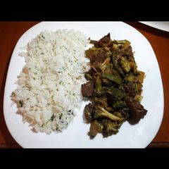 A picture of Meat with broccoli served with white rice.