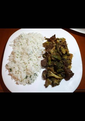 A picture of Meat with broccoli served with white rice.