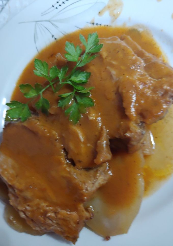 Una foto de Cabeza de cerdo al horno asado en su propio jugo y verduras con patata