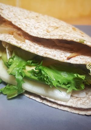 Una foto de Quesadilla de moda de pollo, aguacate y cebolla caramelizada