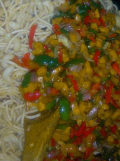 A picture of Pasta with stir fried vegetables and shredded fish.