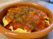 Una foto de ravioli con salsa de pimiento