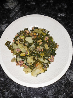 Una foto de Col kale con patata y pistachos