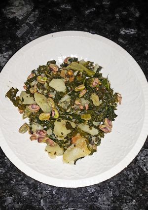Una foto de Col kale con patata y pistachos