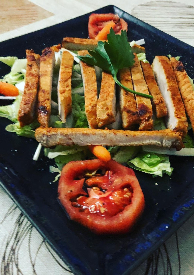 Una foto de Lomo adobado en cama de ensalada mixta