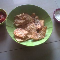 A picture of Nachos with Salsa and Sour Cream.