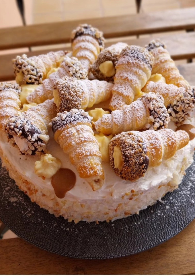 Una foto de Tarta de nata y crema con conos de hojaldre relleno