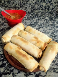 Una foto de Salchichas envueltas con jamón y queso y salsa picante