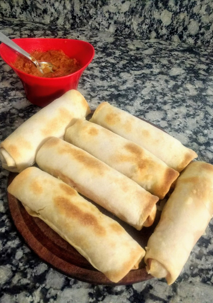 Una foto de Salchichas envueltas con jamón y queso y salsa picante