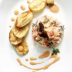 Una foto de Ceviche de salmón y corvina con salsa rosada y batatas al horno