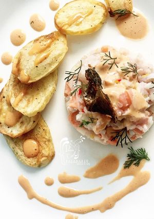 Una foto de Ceviche de salmón y corvina con salsa rosada y batatas al horno
