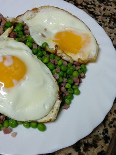 Una foto de Guisantes con jamón y huevo a la plancha