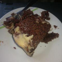 A picture of Chocolate poke cake with white chocolate frosting.