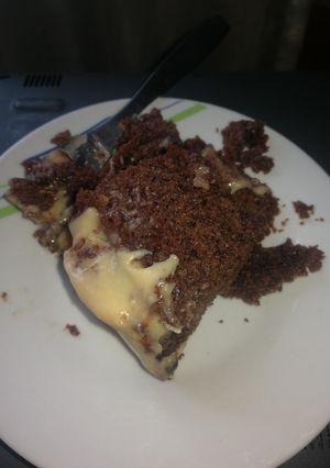 A picture of Chocolate poke cake with white chocolate frosting.