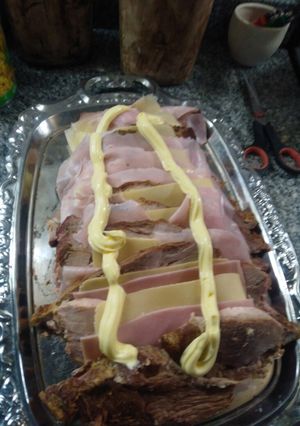 Una foto de Bondiola (cocinada) con jamón y queso y ensalada