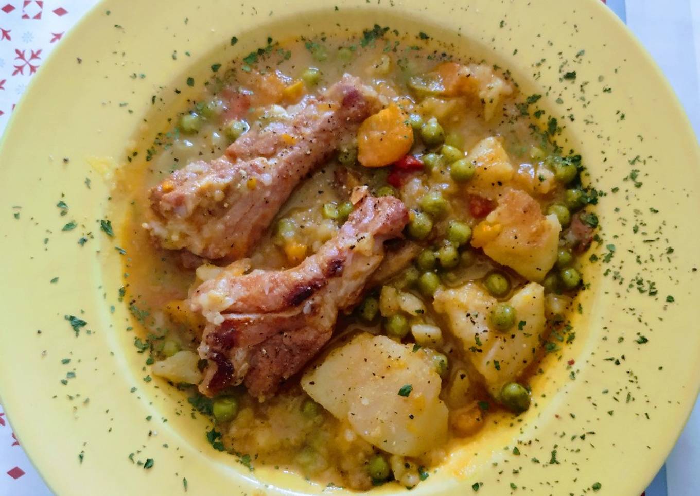 Costillas adobadas guisadas con patatas, guisantes y zanahorias