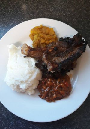 A picture of Lemon lamb chops, pap, chakalaka and cinnamon butternut.