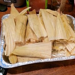 A picture of Pork and Potato Tamales with Green Chile Sauce (Salsa Verde).