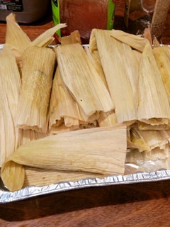 A picture of Pork and Potato Tamales with Green Chile Sauce (Salsa Verde).