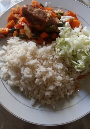 A picture of White rice and carrot sauce with cos low.