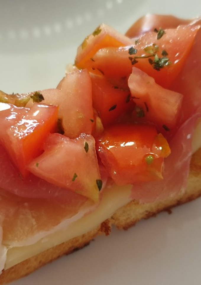 Una foto de 🍅🧀🍞 Pan tostado con ajo, tomate, queso semi y serrano