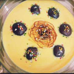A picture of Gulab jamun in custard.