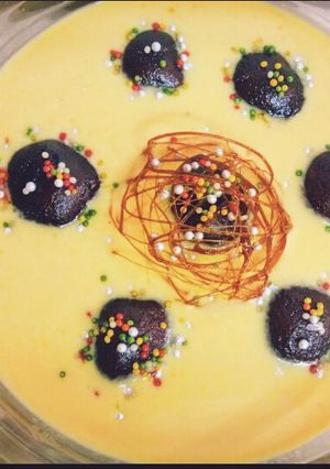 A picture of Gulab jamun in custard.