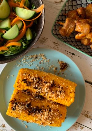 A picture of Grilled sweet corn with coconut crumbs.