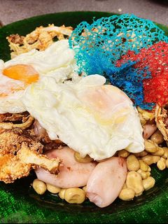 Una foto de Habitas con chipirones, huevos fritos y cebolla crunchi con decoración de corales