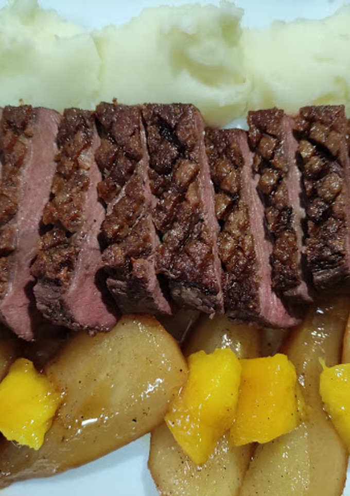 Una foto de Magret de pato con puré de patata acompañado de peras y dados de mango agridulces