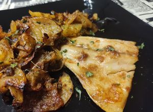 Foto principal de Lecha (Pez Limón) al horno con cama de patatas y cebollas al pimentón y hierbas Provenzales