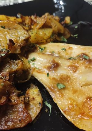 Una foto de Lecha (Pez Limón) al horno con cama de patatas y cebollas al pimentón y hierbas Provenzales