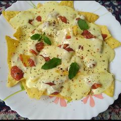 A picture of Nachos with cheese dip.