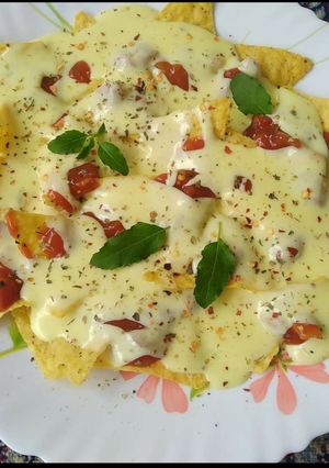A picture of Nachos with cheese dip.