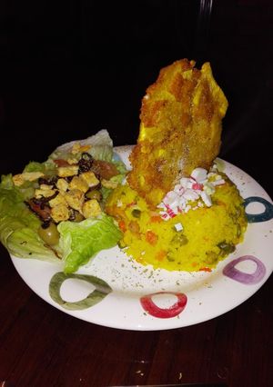 Una foto de Arroz con camarones y palmitos de cangrejo, acompañado de patacón pisado y ensalada