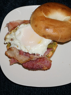 Una foto de Huevos fritos con tocino sobre bagels