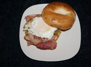 Una foto de Huevos fritos con tocino sobre bagels