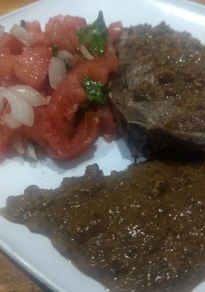 Una foto de Lomo en salsa de hongos, tomates secos y ajo con ensalada fresca