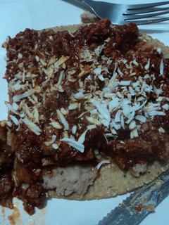 Una foto de Garnacha asada con chicharrón en salsa de chile cascabel y frijolitos con hierbas de olor