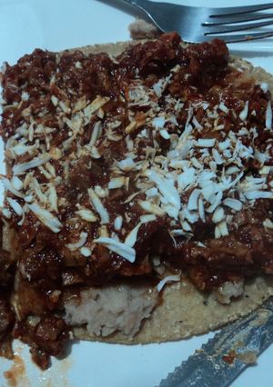 Una foto de Garnacha asada con chicharrón en salsa de chile cascabel y frijolitos con hierbas de olor