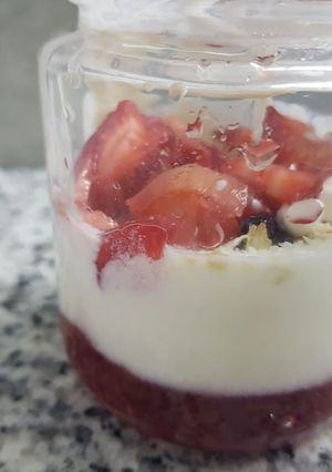 Una foto de Yogur hecho con kéfir con frutillas coco y pasas de uva
