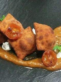 Una foto de Ravioles fritos de queso y chorizo con pesto de tomate