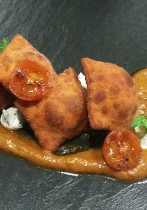 Una foto de Ravioles fritos de queso y chorizo con pesto de tomate