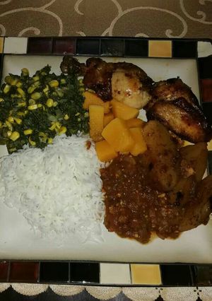 A picture of Grilled chicken with spinach and corn.