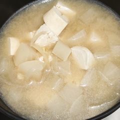 A picture of Miso soup with tofu, daikon, onion.