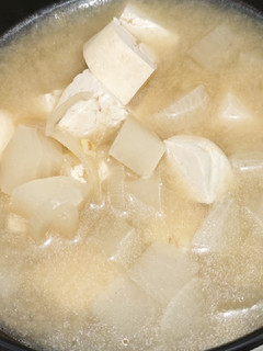A picture of Miso soup with tofu, daikon, onion.
