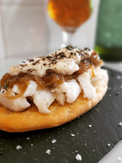 Una foto de Coca de bacalao confitado, cebolla caramelizada y salsa cabrales