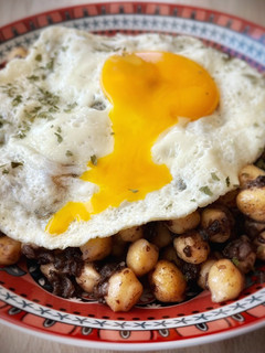 Una foto de Garbanzos salteados con morcilla y huevo frito